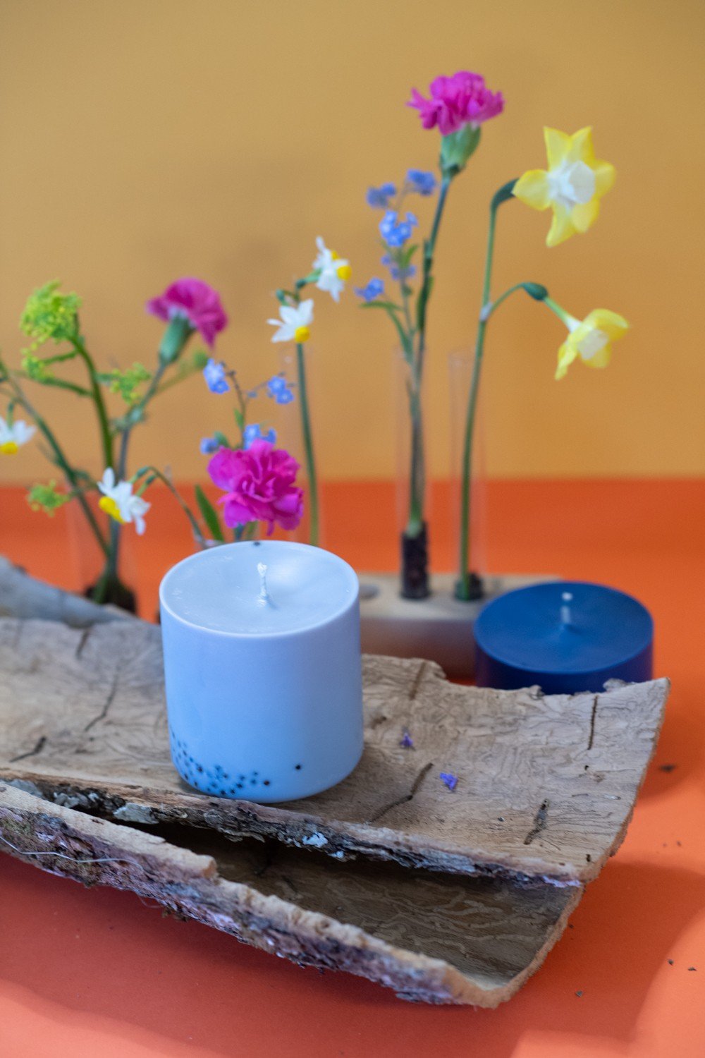 4. TL Candles hand-made soy wax candle with patchouli scent, styled with colorful flowers on a wooden surface