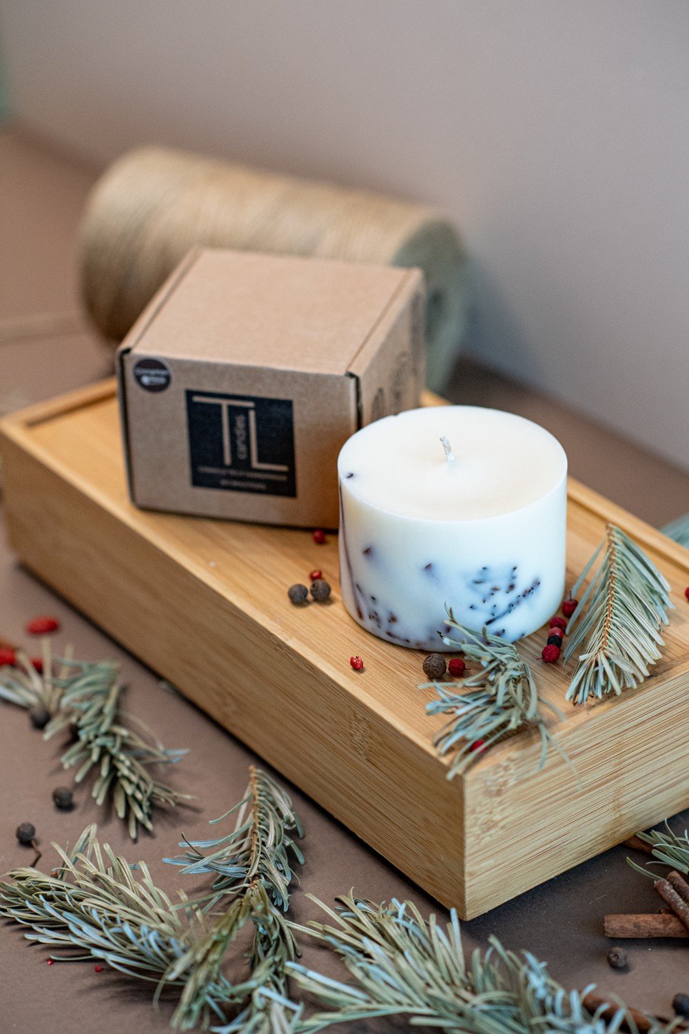 5. TL Candles soy wax candle with cinnamon and clove, shown with packaging on wooden tray