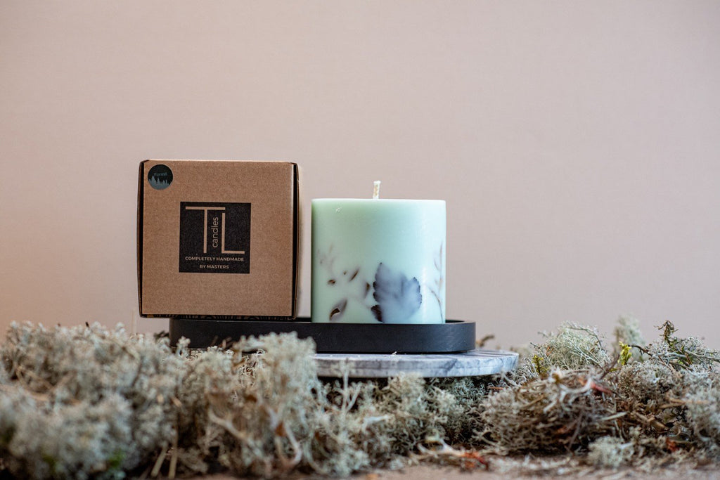 5. TL Candles mint green soy wax candle with forest scent, displayed with packaging on a black tray