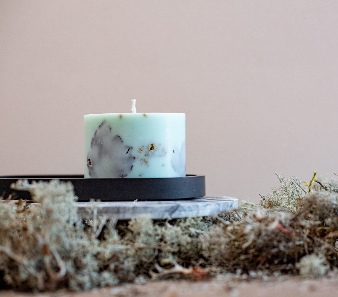 7. Close-up of hand-made mint green soy wax candle with forest scent, surrounded by moss