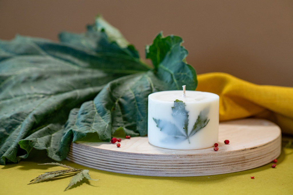 1. Hand-made soy wax candle with Clary Sage scent and hemp leaf decoration on wooden base, lifestyle setting