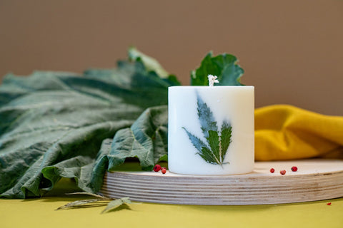 4. Close-up of TL Candles soy wax candle with Clary Sage scent and hemp leaf decoration, lifestyle setting