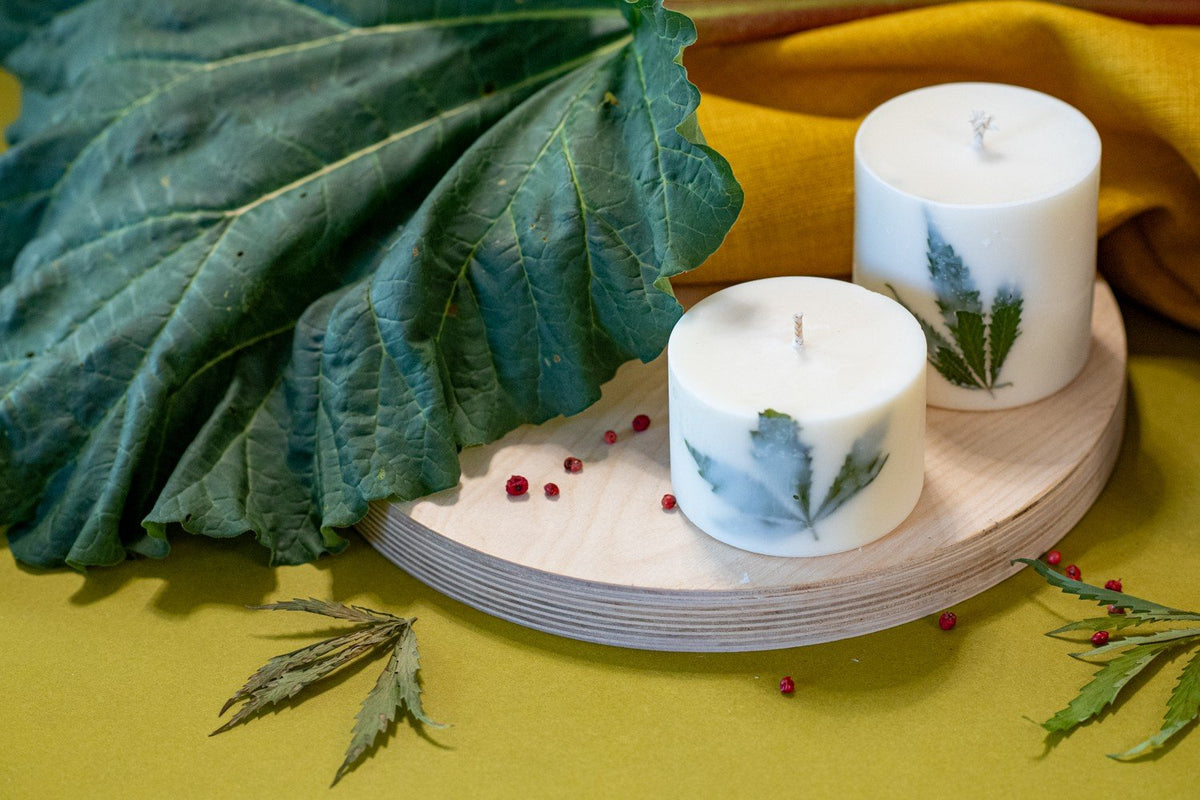 6. Pair of TL Candles soy wax candles with Clary Sage scent and hemp leaves, displayed on wooden base