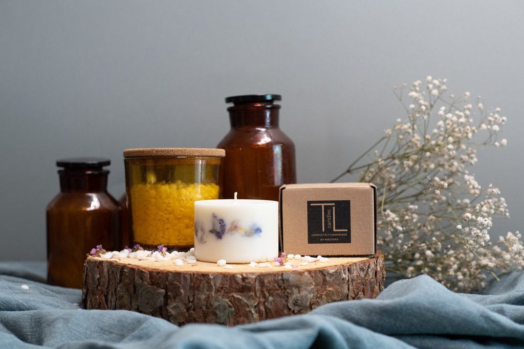 3. Hand-made unscented soy wax candle with dried flowers by TL Candles, displayed with packaging and decorative jars