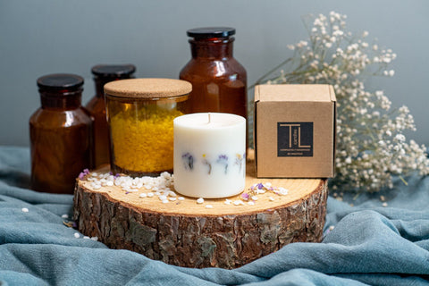 4. Hand-made unscented soy wax candle with dried flowers by TL Candles, shown with packaging on a wooden slab