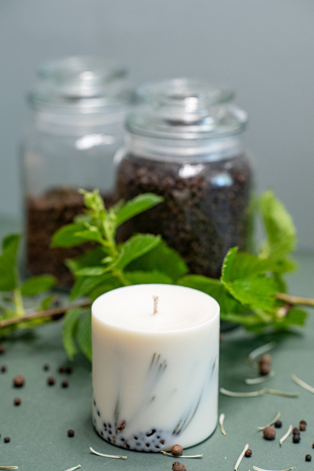 7. Close-up of TL Candles hand-made soy wax candle with juniper fragrance, styled with fresh greenery