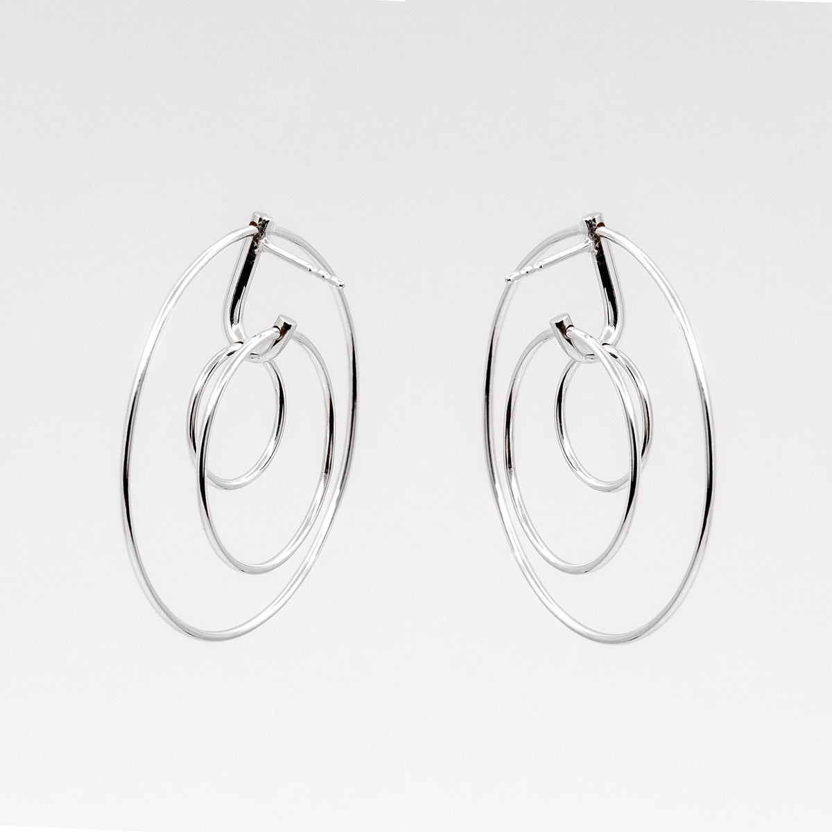 2. Studio image of Maarja Palu LAYERS x3 earrings featuring three interlocking silver circles