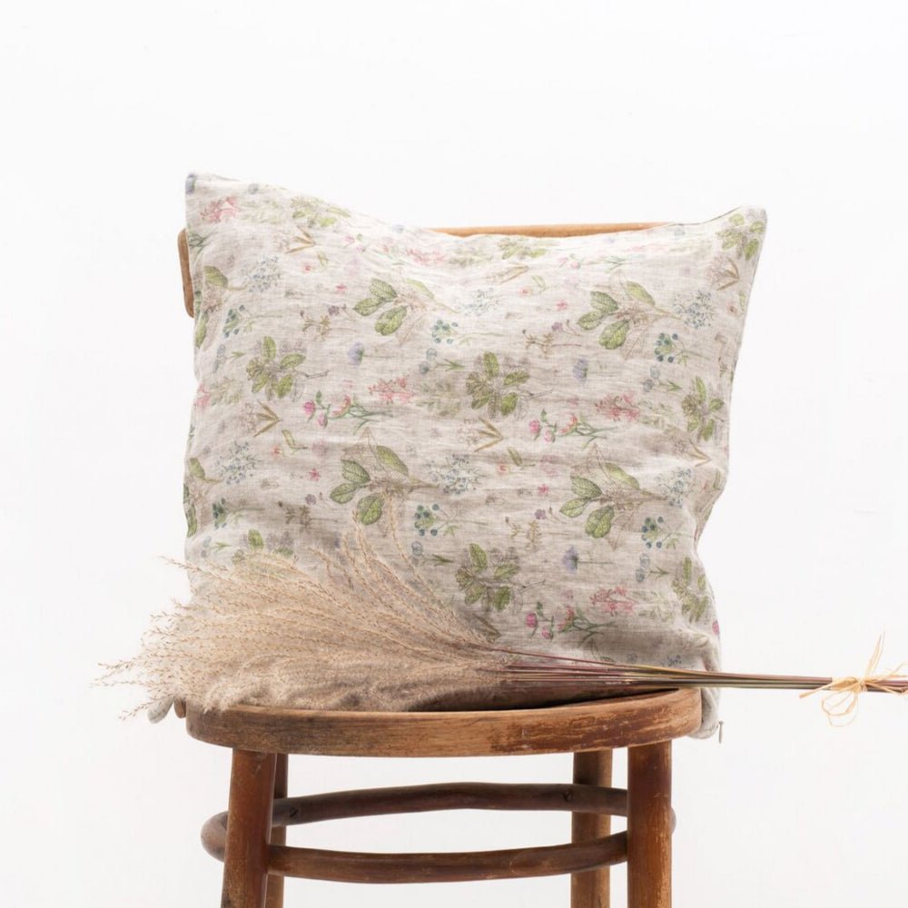 4. Floral Linen Tales cushion cover on a wooden chair with decorative dried grass