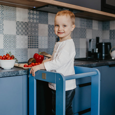 1. Child using blue MeowBaby kitchen helper at kitchen counter with vegetables