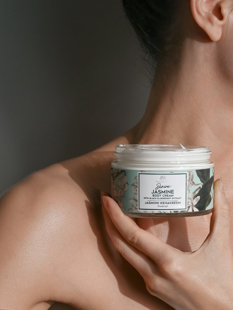 1. Woman holding Magrada Organic Cosmetics Jasmine Body Cream with black elderberry extract, showcasing product packaging