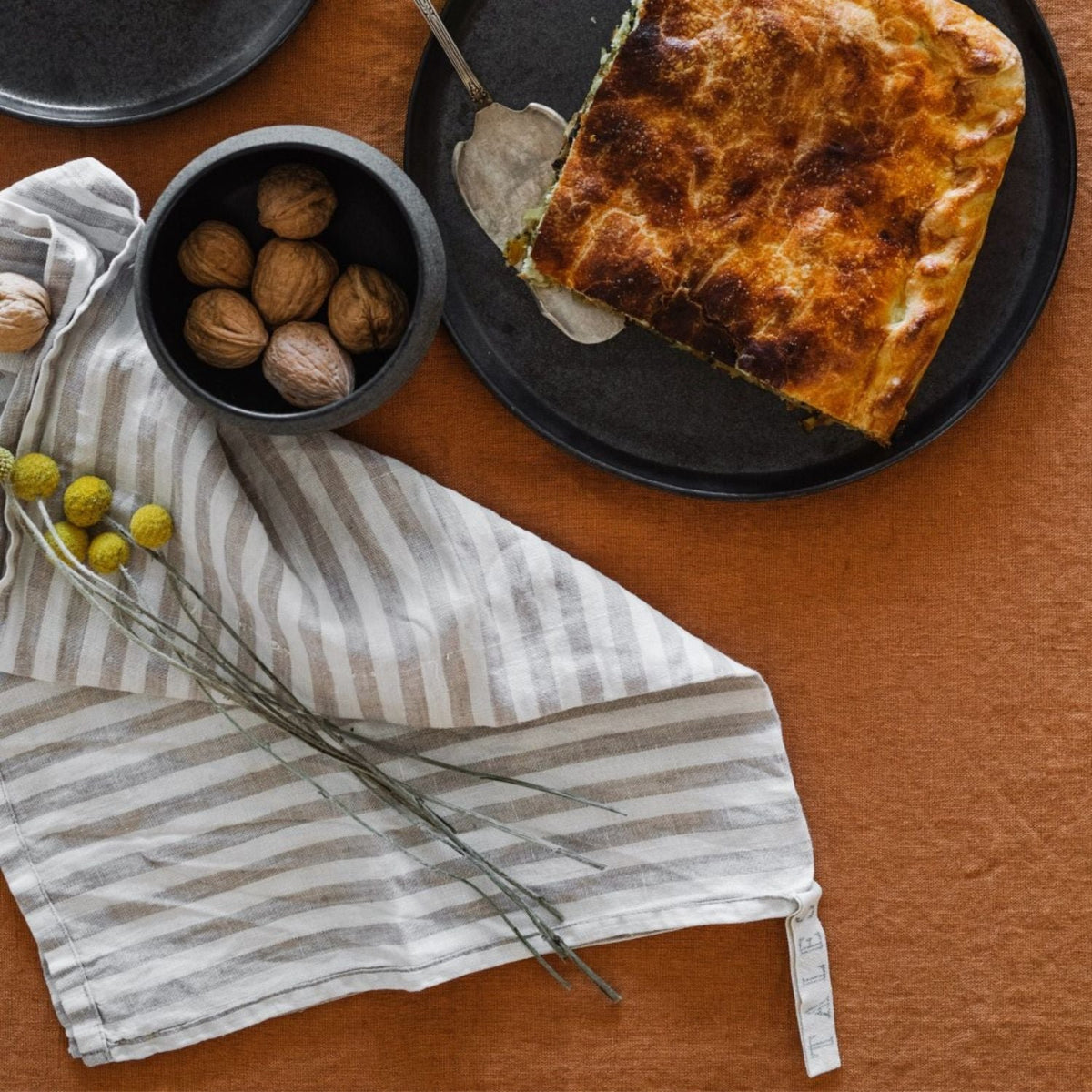 2. Striped linen kitchen towel on table with walnuts and baked dish