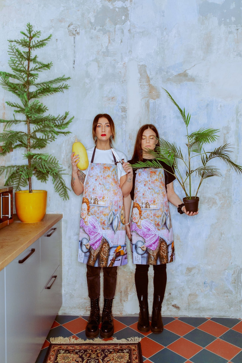 5. Two Katrin Valgemäe aprons with pop art kitchen design, featuring humorous and eclectic elements, displayed on patterned rug