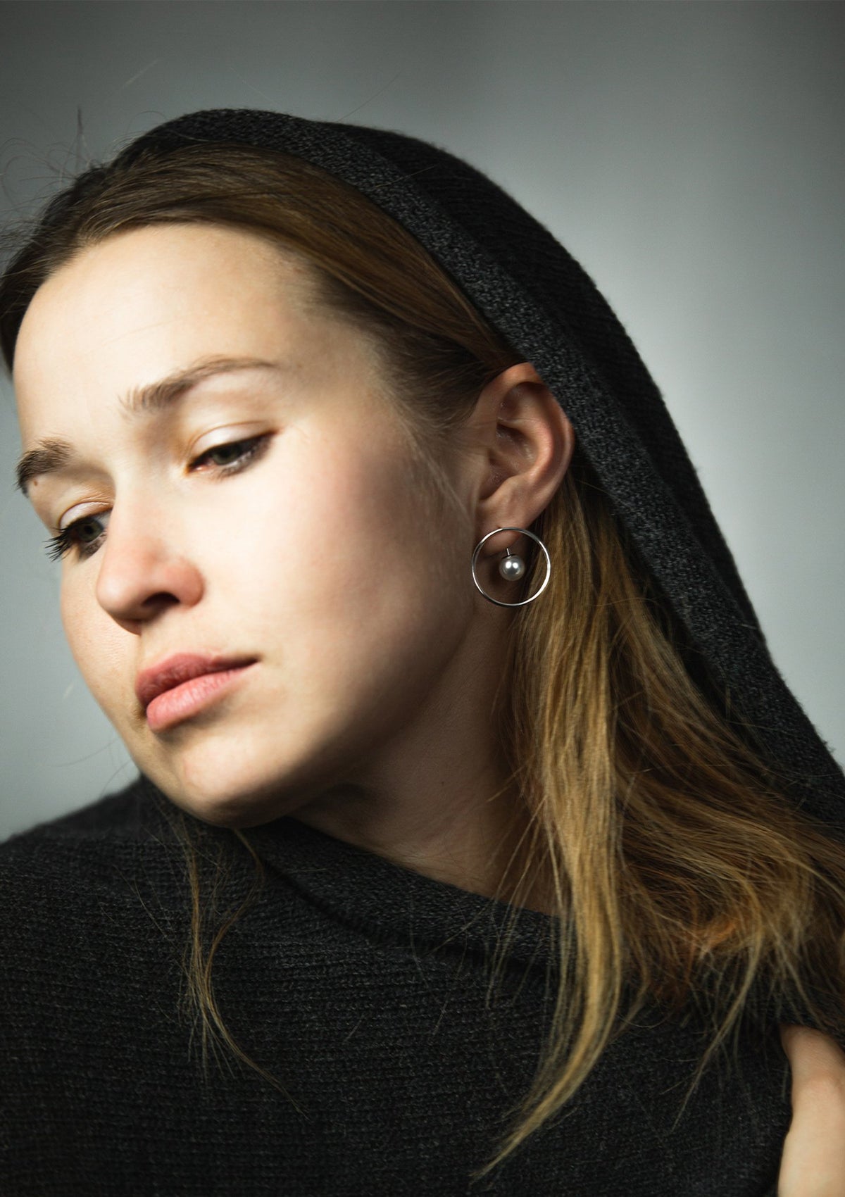 1. Woman wearing Maarja Palu SPOT earrings with pearl and silver circle, showcasing minimalist design