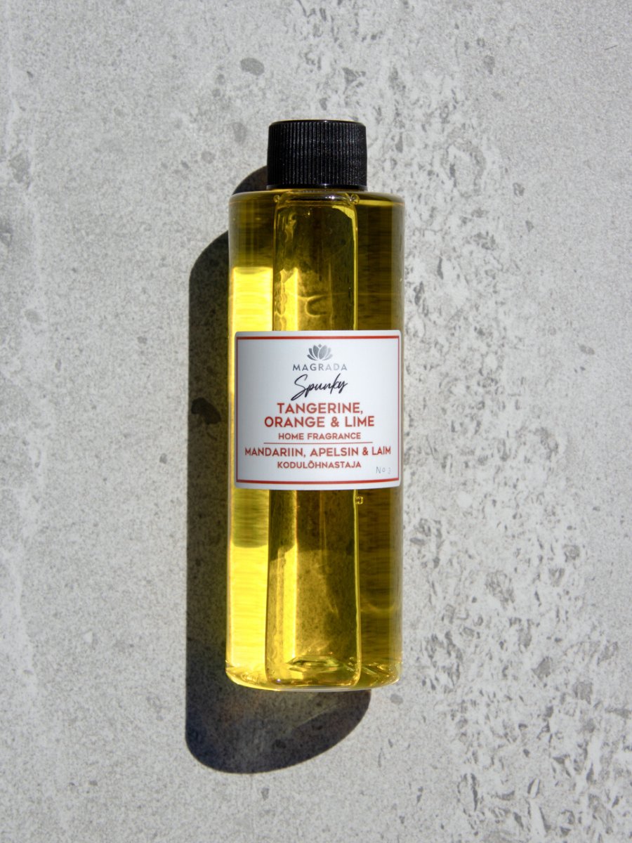 2. Close-up of Magrada Spunky home fragrance refill bottle featuring tangerine, orange, and lime blend, displayed on a stone background