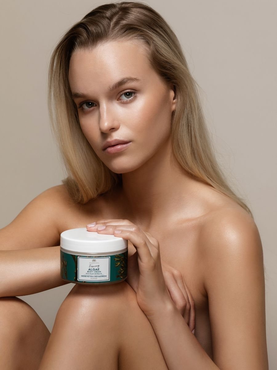 1. Woman holding Magrada Organic Cosmetics Firming Algae Body Cream, showcasing product packaging
