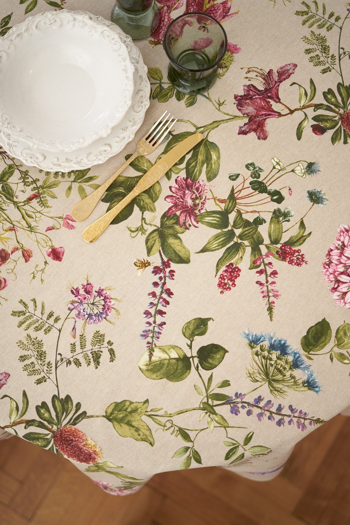 2. Top view of Hortensias Home Botanico round floral tablecloth with plates and cutlery, highlighting detailed floral design