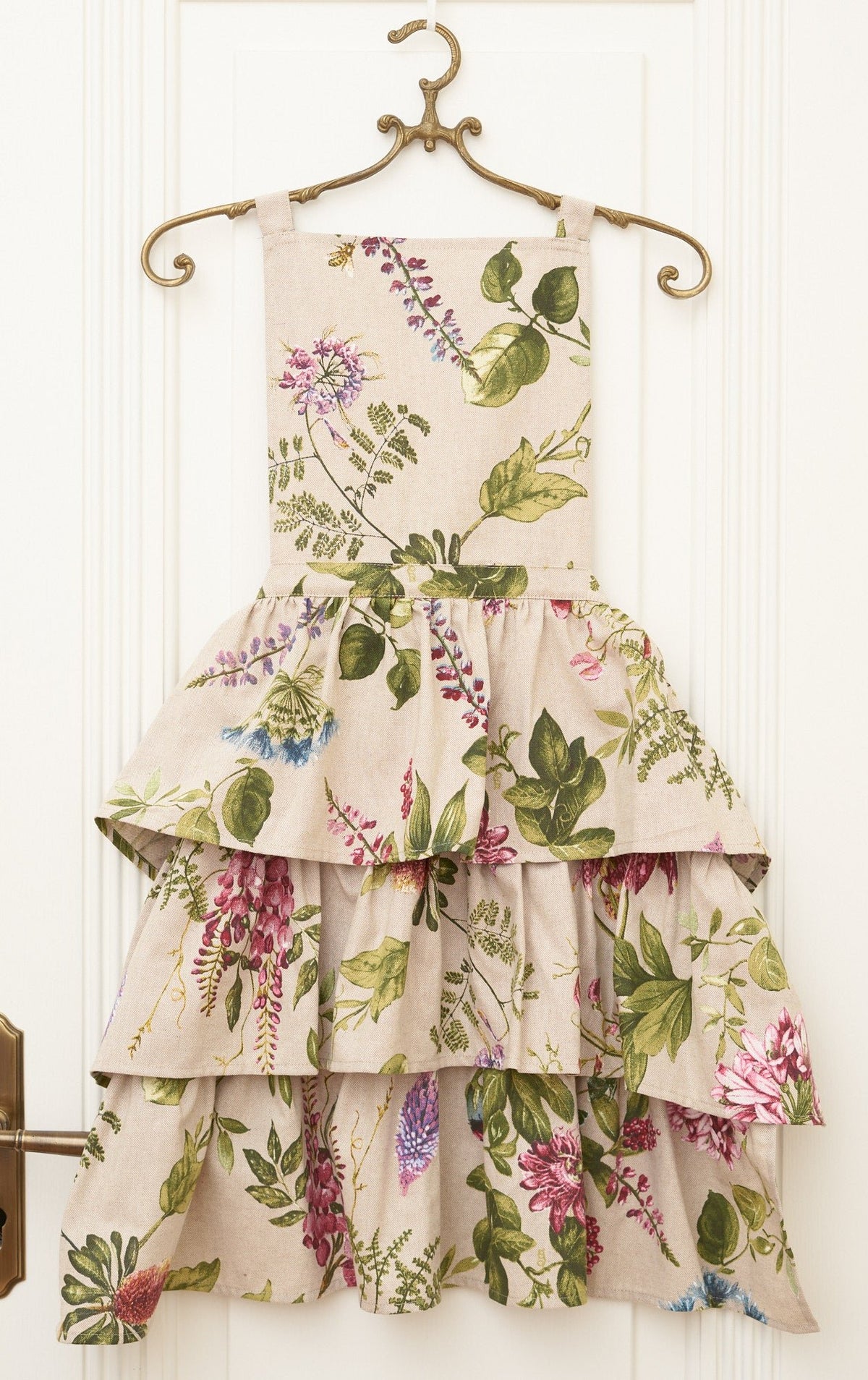 3. Studio shot of Hortensias Home Botanico floral ruffled apron on hanger
