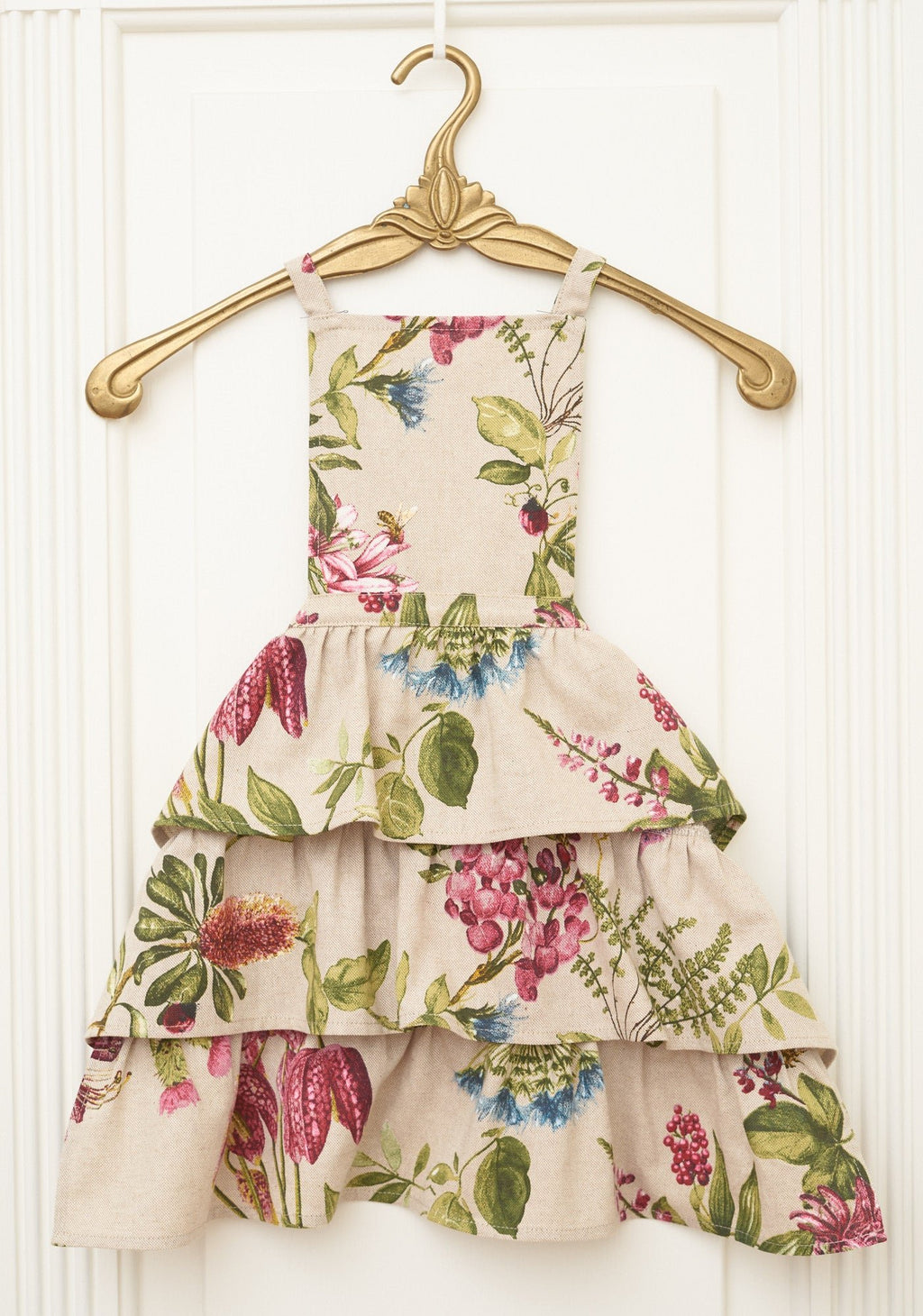 3. Studio shot of Botanico Kids Apron by Hortensias Home, highlighting floral print and tiered design