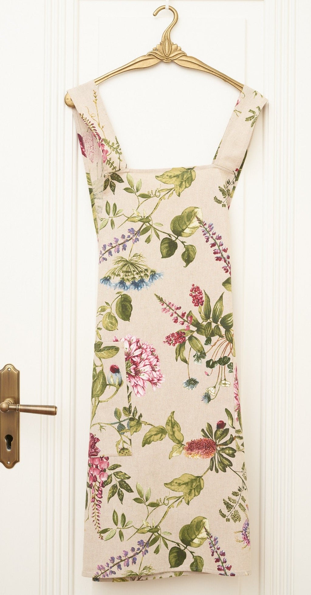 3. Studio shot of Hortensias Home Botanico floral apron with crossed straps on hanger