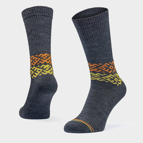 1. Unisex dark grey merino wool socks by Baltland, featuring a colorful tradition-inspired pattern, shown in a studio setting