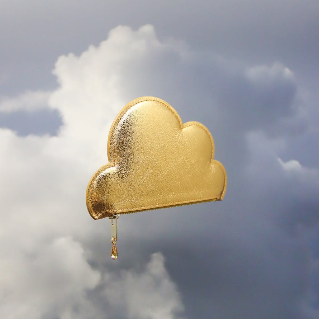 2. Tairi Roosve gold leather cloud purse with Swarovski crystal zip floating against cloudy sky