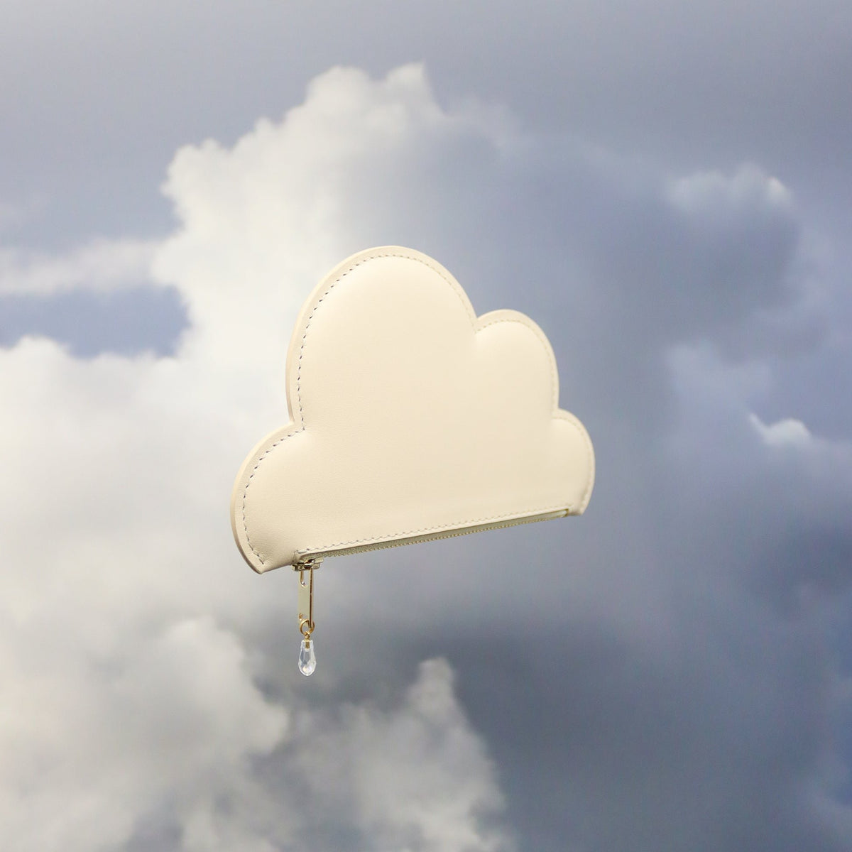 5. Tairi Roosve beige leather cloud purse with Swarovski crystal zip, side view in cloudy sky