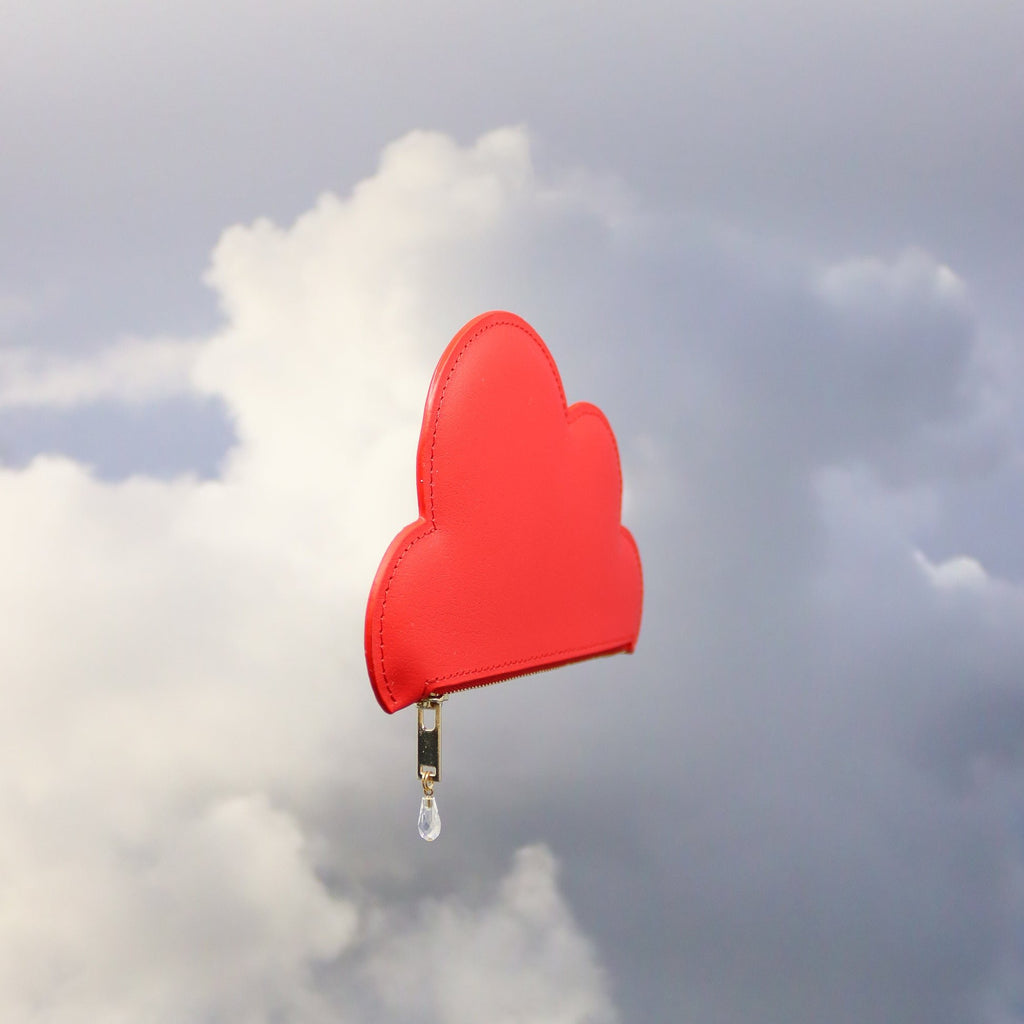 3. Angled view of Tairi Roosve red leather cloud purse with Swarovski crystal zip, against a cloudy sky
