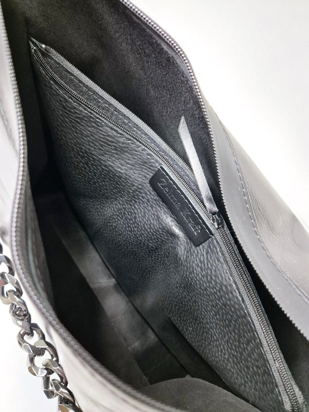 9. Interior view of Zelma Kraft black leather hobo bag showing zippered pocket and Zelma Kraft branding