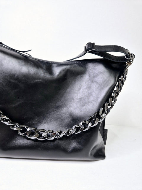 4. Woman wearing Zelma Kraft black leather hobo bag with gold chain strap, shown from the back