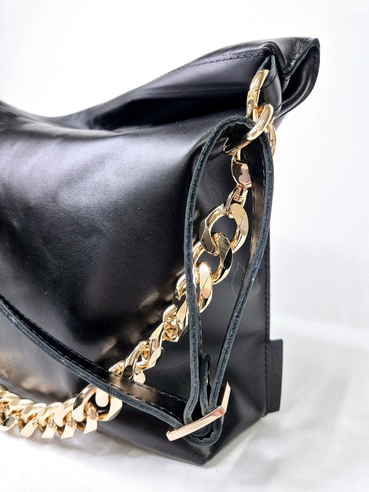 7. Side view of Zelma Kraft black leather hobo bag with gold chain and leather strap