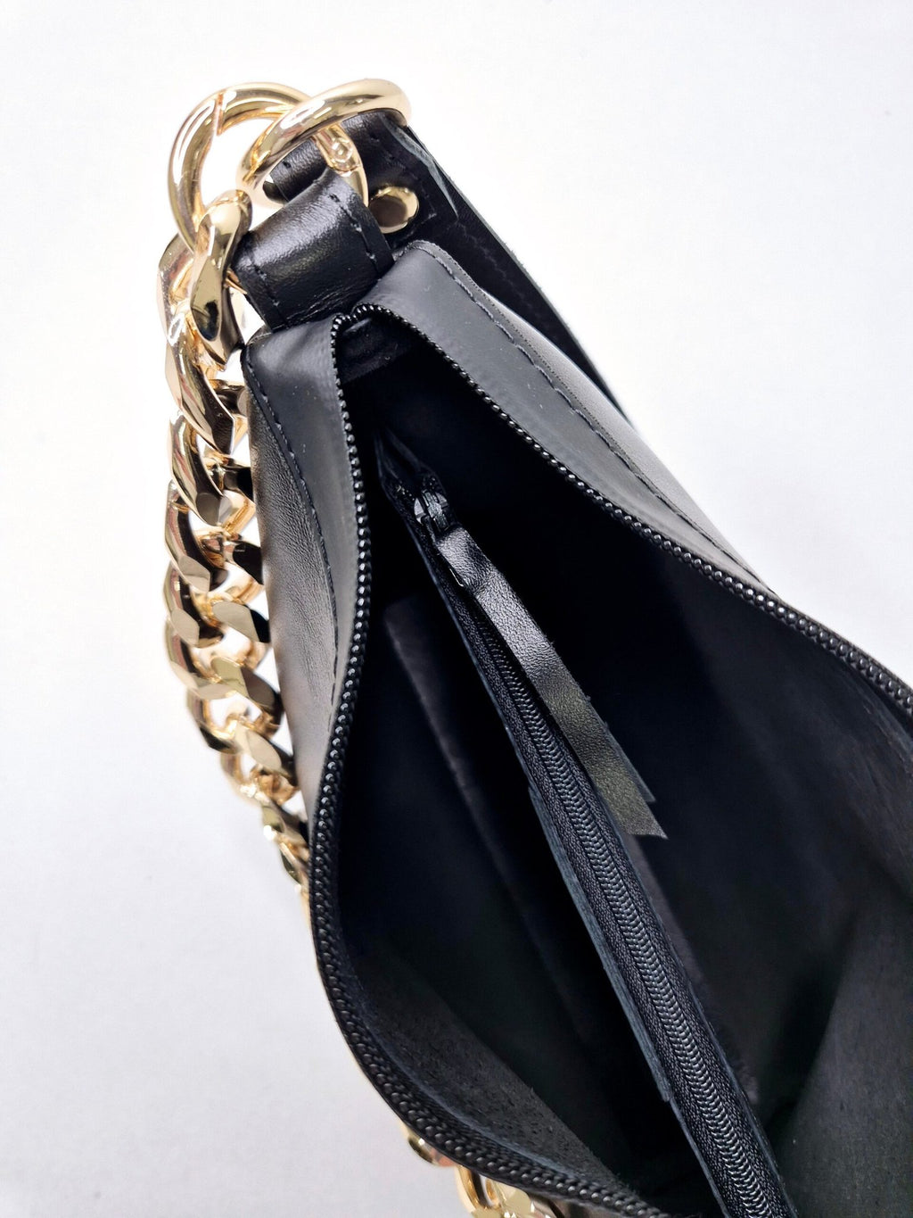 10. Close-up of Zelma Kraft black leather hobo bag interior with gold chain and zippered compartments