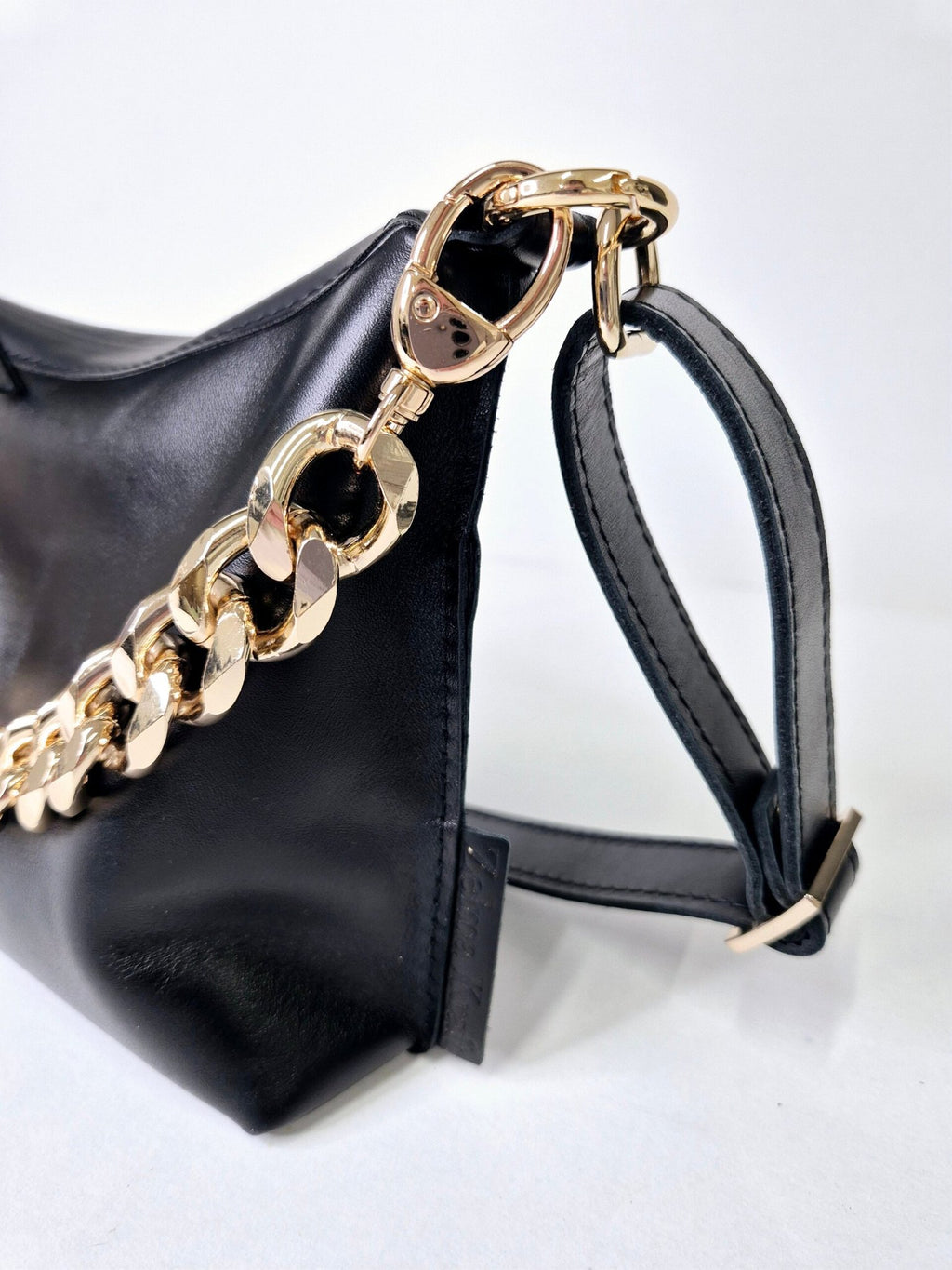 8. Close-up of Zelma Kraft black leather hobo bag with gold chain and adjustable strap