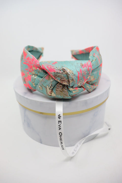 3. Eva Oherjus Knot Headband Misty shown on luxury hat box with brand name tag