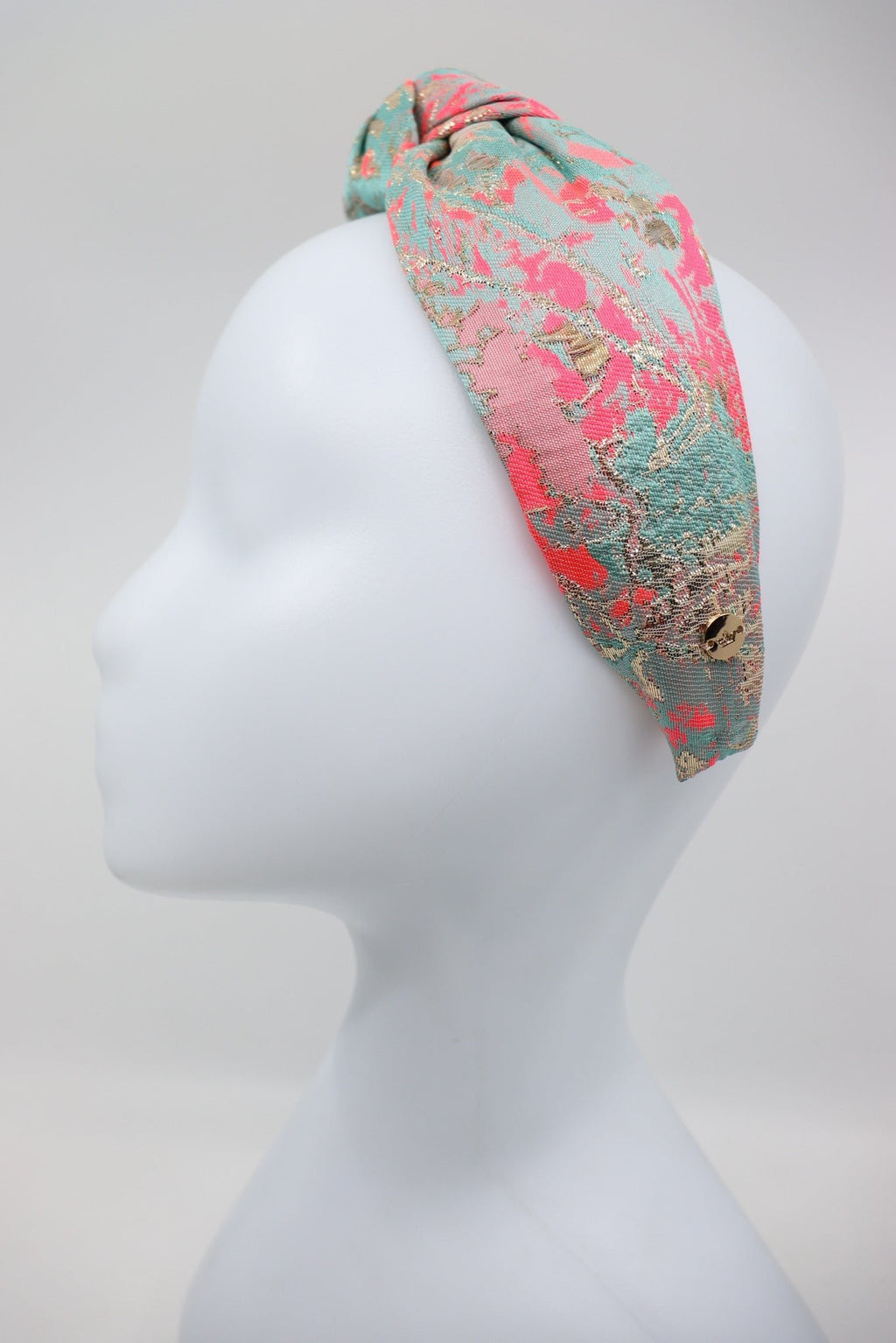 5. Eva Oherjus Knot Headband Misty on mannequin head, showcasing vibrant colors and knot detail