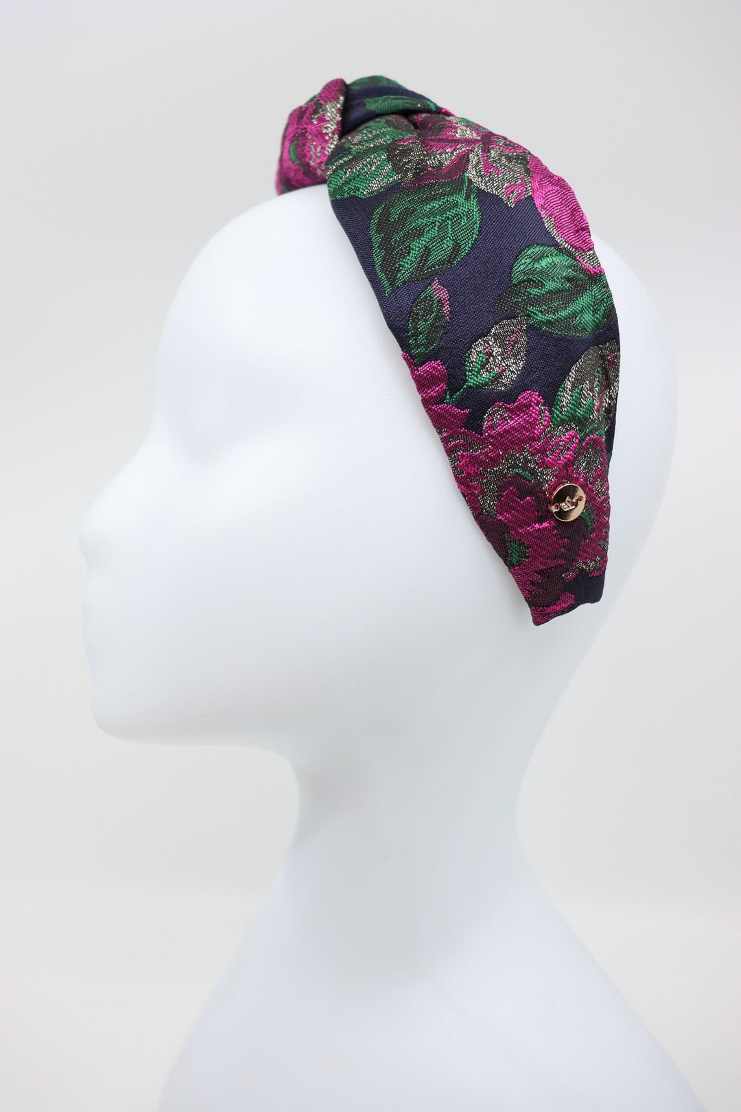 4. Studio shot of Knot Headband Flora by Eva Oherjus, showcasing vibrant floral motif and golden logo tag