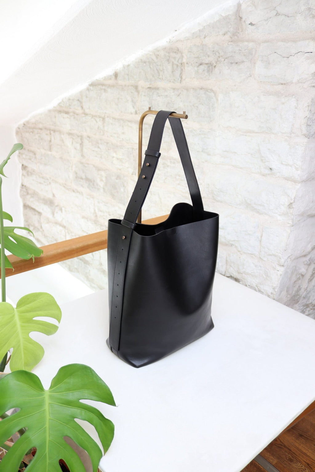 4. Studio shot of Tairi Roosve black leather tote bag with adjustable strap, showcasing sleek design and craftsmanship