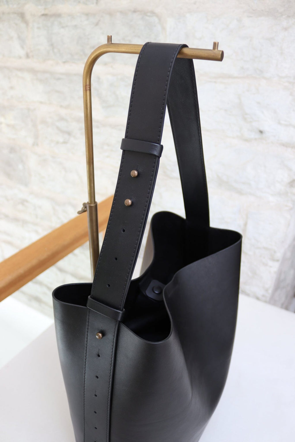 9. Tairi Roosve black leather tote bag with adjustable strap, shown on table with removable clutch