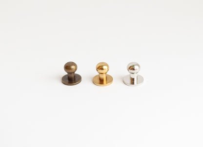 11. Close-up of three metal press studs in different finishes for Tairi Roosve leather tote bag