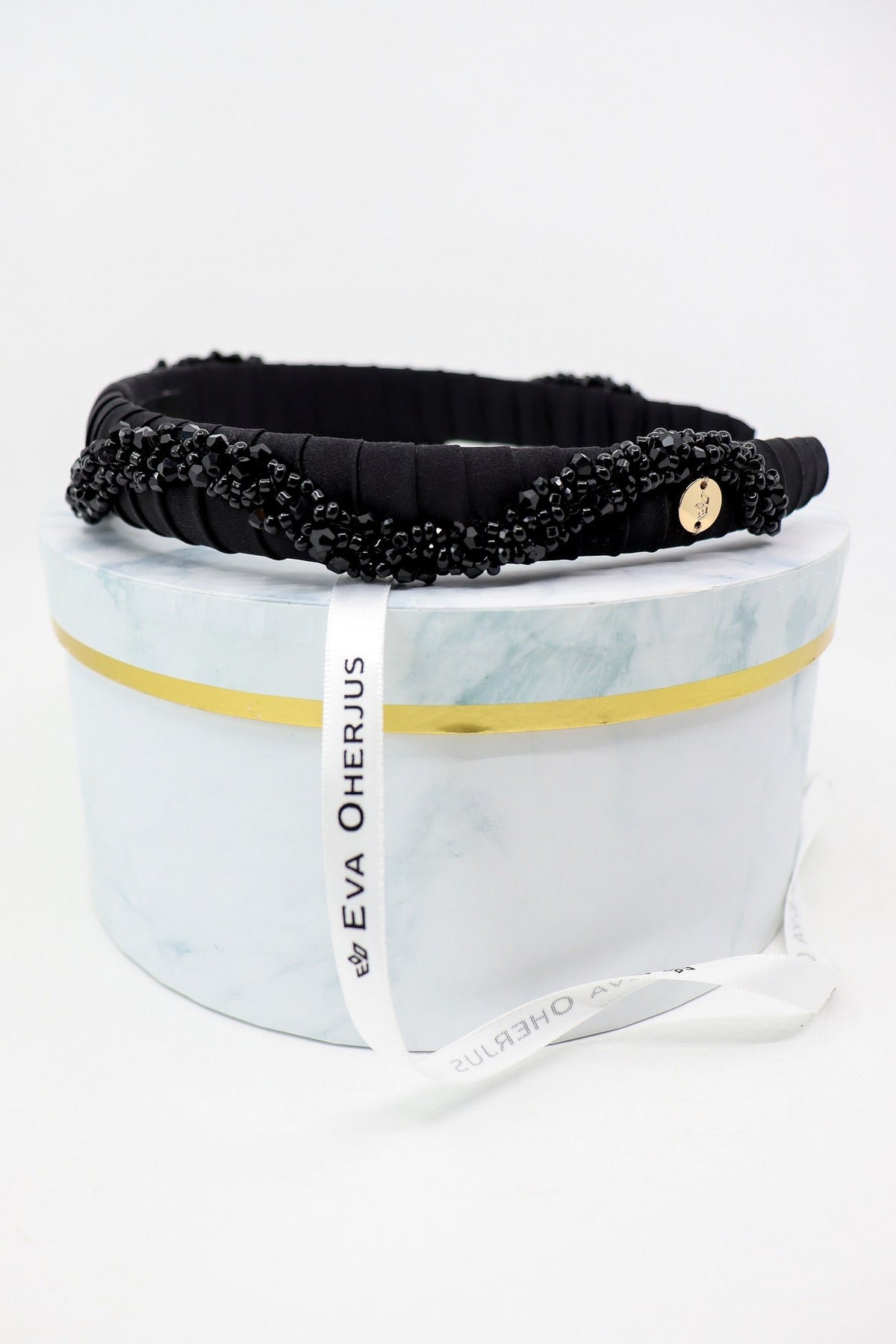 1. Eva Oherjus Beaded Thin Mulberry Silk Headband Hestia displayed on luxury hat box with logo tag