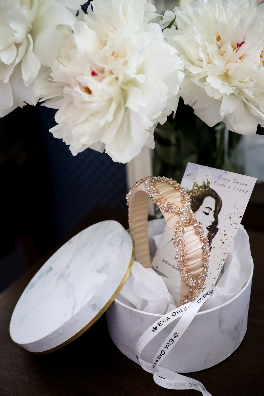 2. Eva Oherjus Mulberry Silk Headband Ada in open luxury hat box with floral background