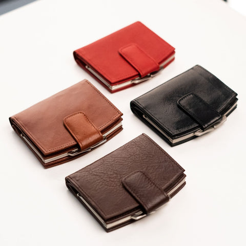 4. Studio shot of Papillon women's leather wallets in red, black, cognac, and dark brown, showing metal-framed edges