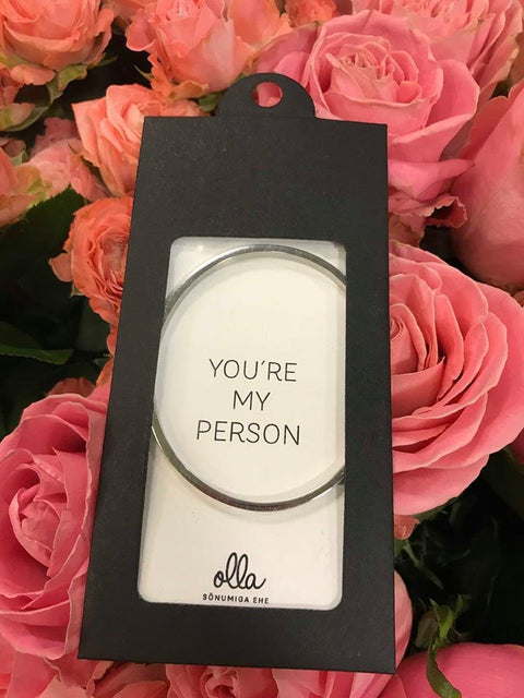 3. Olla 'You're My Person' bracelet in packaging with pink roses background