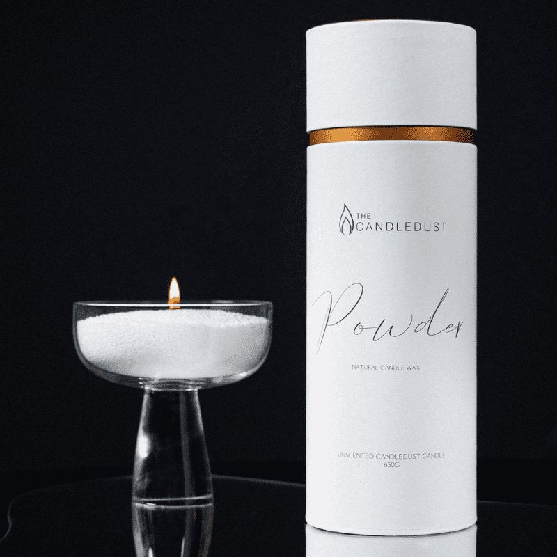 7. Studio shot of Candledust powdered candle in a glass dish next to its branded packaging