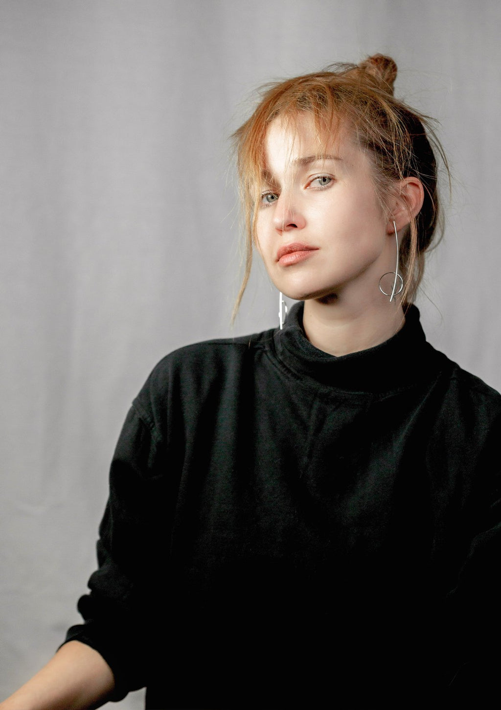 1. Woman wearing Maarja Palu HARMONY silver earrings, showcasing minimalist design in lifestyle setting