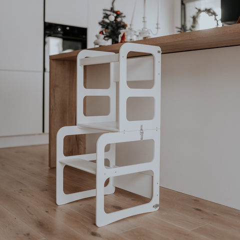 1. White 2-in-1 kitchen tower in step stool mode next to a wooden kitchen counter