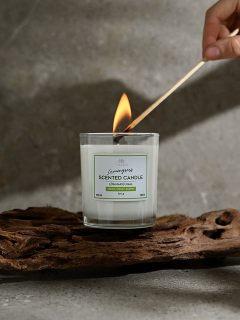 1. Magrada Organic Cosmetics lemongrass scented candle being lit with a match, showcasing its fresh citrusy aroma and eco-friendly design