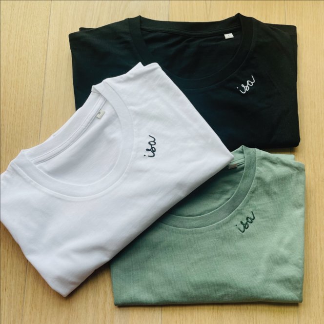 10. Flat lay of white organic cotton T-shirt by Beebila with embroidered collar on wooden surface