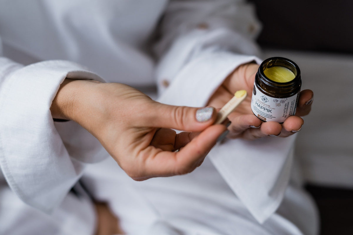 2. Close-up of MaiWistik HAPPIK Rejuvenating Face Balm being applied with a spatula, highlighting texture and application method