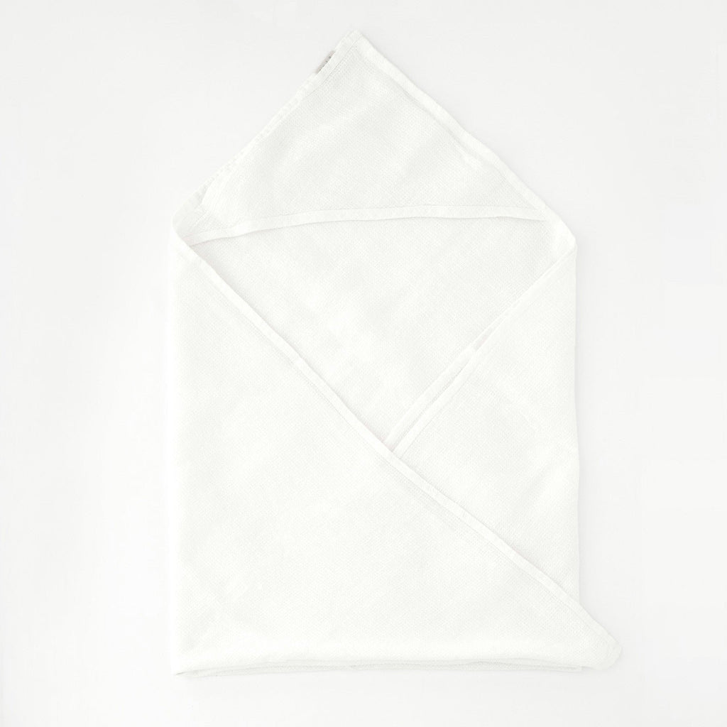 2. White linen hooded waffle towel for kids laid flat on a clean white background