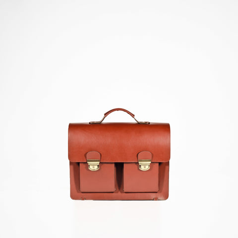 1. Papillon Briefcase No. 35 in cognac vegetable-tanned leather, featuring dual front pockets and a top handle, shown in studio setting
